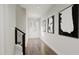 Clean hallway with wood floors and modern wall art leading to the front door at 4046 Elk Creek Ln # 62, Raleigh, NC 27612