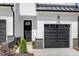 Front view of townhome with black garage door and dark front door at 4047 Elk Creek Ln # 13, Raleigh, NC 27612