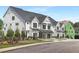 Row of townhomes with white siding, black garage doors, and landscaping, under construction homes visible at 4047 Elk Creek Ln # 13, Raleigh, NC 27612