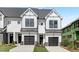 Two-story townhome with white siding, black garage doors, and landscaping at 4047 Elk Creek Ln # 13, Raleigh, NC 27612