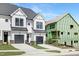 Two-story townhomes with white siding and black garage doors, under construction homes visible at 4047 Elk Creek Ln # 13, Raleigh, NC 27612