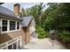 House exterior with stone chimney, basketball court, and wooded backdrop at 621 Sugarberry Rd, Chapel Hill, NC 27514