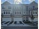 Two-story townhome with gray siding, stone accents, and two-car garage at 6912 Woodland Stream Pl, Raleigh, NC 27616