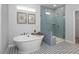 Bathroom with a large soaking tub, glass shower, and patterned floor tiles at 5013 Trotter Dr, Raleigh, NC 27603