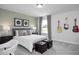 Modern bedroom with a comfy bed, two ottomans, and guitar decor at 5013 Trotter Dr, Raleigh, NC 27603