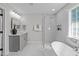 Modern bathroom with gray vanity, soaking tub, and walk-in shower at 4811 Homeplace Dr, Apex, NC 27539