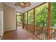 Spacious screened porch with wood flooring, ceiling fan, and wooded views at 8406 Wheatstone Ln, Raleigh, NC 27613