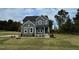 Two story home with gray siding, landscaping, and stone accents at 230 Grading Stick Ct, Angier, NC 27501