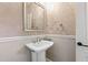 Chic powder room with pedestal sink, silver framed mirror, and textured wallpaper at 3700 Lark Farm Rd, Franklinton, NC 27525