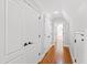 Long hallway with hardwood floors and white doors leading to bedrooms at 3700 Lark Farm Rd, Franklinton, NC 27525