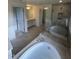 Elegant bathroom with soaking tub, shower, and double vanity at 23 Quail Pt Cir, Clayton, NC 27520