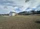 Rear view of a two-story house with a deck overlooking a large backyard at 23 Quail Pt Cir, Clayton, NC 27520