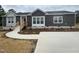 Modern single-story home with gray siding, landscaped yard, and concrete driveway at 6733 Oscar Barham Rd, Wake Forest, NC 27587