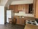 Basic kitchen with wood cabinets, stove, and refrigerator at 414 E Morehead St, Burlington, NC 27215