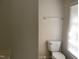 Simple bathroom with toilet, wall-mounted towel rack, and window at 414 E Morehead St, Burlington, NC 27215