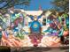 Vibrant building mural depicting a train and figures at 202 Byrum St # 2, Cary, NC 27511