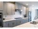 Modern kitchen with gray cabinets, stainless steel appliances, and white quartz countertops at 10420 Sablewood Dr # 115, Raleigh, NC 27617