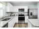 White kitchen features stainless steel appliances and granite countertops at 6669 Gibraltar Rock Dr # 1128C, Raleigh, NC 27610