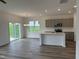 Open concept kitchen with island, gray cabinets, and view of backyard at 87 Furley St., Homesite 112, Sanford, NC 27330