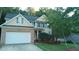 Two-story house with beige vinyl siding, a white garage door, and landscaping at 65 Applegate Dr, Franklinton, NC 27525