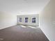Upstairs bedroom with three windows and neutral decor at 9 Oxmoor Dr, Durham, NC 27703