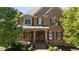 Brick home with a metal roof, double front doors, and landscaping at 206 Felspar Way, Cary, NC 27518