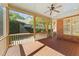 Relaxing screened porch with wood flooring and ceiling fan, overlooking backyard at 206 Felspar Way, Cary, NC 27518