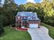 Two story home with brick and gray siding, two car garage, and landscaping at 319 River Knoll Dr, Clayton, NC 27527