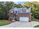 Two story home with brick and gray siding, two car garage, and landscaping at 319 River Knoll Dr, Clayton, NC 27527