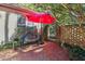 Relaxing patio area with brick flooring and a red umbrella at 675 Whitehurst, Pittsboro, NC 27312