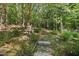 Stone path winds through a lush, wooded garden at 675 Whitehurst, Pittsboro, NC 27312