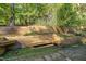 Landscaped backyard with stone path and wooden seating at 675 Whitehurst, Pittsboro, NC 27312