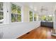 Sunroom features hardwood floors, built-in cabinetry, and large windows at 26 Oak St, Roxboro, NC 27573