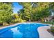 Relaxing kidney-shaped pool surrounded by lush greenery at 26 Oak St, Roxboro, NC 27573