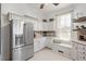 Kitchen features stainless steel refrigerator and white cabinets at 26 Oak St, Roxboro, NC 27573