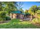 Rustic guest house with green metal roof and fenced yard at 26 Oak St, Roxboro, NC 27573