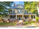 Large two-story house with a wrap-around porch and brick accents at 26 Oak St, Roxboro, NC 27573