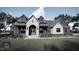 Modern farmhouse exterior with stone accents at Lot 5 Joyful Creek Trl, Zebulon, NC 27597