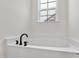 White bathtub with oil-rubbed bronze fixtures and a bright window at 420 Oak Park Blvd, Youngsville, NC 27596