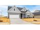 Front exterior of a two-story gray house with a white garage door and driveway at 420 Oak Park Blvd, Youngsville, NC 27596