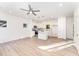 Open living room and kitchen with light hardwood floors and ceiling fan at 112 N Guthrie Ave # A, Durham, NC 27703