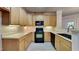 Kitchen with light wood cabinets, black appliances, and tile floors at 1414 Arborgate Cir, Chapel Hill, NC 27514
