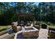 Stone fire pit with wicker seating, under a pergola at 2117 Blue Haven Ct, Wake Forest, NC 27587