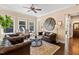Elegant sitting room boasts leather sofas, a wood coffee table, and large windows at 2117 Blue Haven Ct, Wake Forest, NC 27587