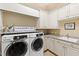 Bright laundry room with washer, dryer, and ample cabinetry at 2117 Blue Haven Ct, Wake Forest, NC 27587