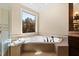 Bathroom featuring corner soaking tub and large window at 2117 Blue Haven Ct, Wake Forest, NC 27587