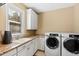 Bright laundry room with white cabinets, granite countertops, and new appliances at 2117 Blue Haven Ct, Wake Forest, NC 27587