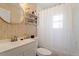 Clean bathroom with white vanity, geometric wallpaper, and a shower/tub combo at 113 Higbee St, Durham, NC 27704