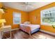 Bedroom with orange walls, hardwood floors, and a ceiling fan at 113 Higbee St, Durham, NC 27704