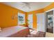 Bright bedroom with orange walls, hardwood floors, and a ceiling fan at 113 Higbee St, Durham, NC 27704